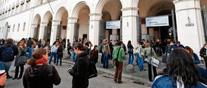 Junge Leute stehen vor einem Universitätsgebäude.