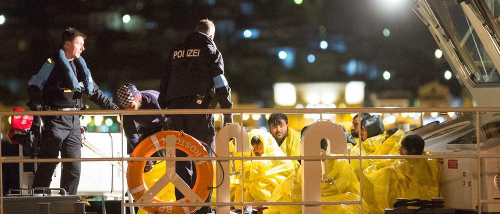 Beamte der Bundespolizei See an Bord des Streifenboots "Börde" helfen in der Nacht zum 03.03.2016 im Hafen von Vathy auf der Insel Samos (Griechenland) Flüchtlingen von Bord, die sie zuvor bei einer Einsatzfahrt in der Ägäis aufgenommen haben.