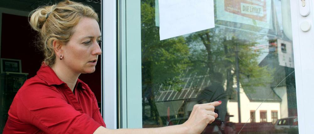 Die Linken-Bundestagsabgeordnete Caren Lay zeigt die bei einem Angriff beschädigte Tür ihres Wahlkreisbüros in Hoyerswerda. Ihre Büros wurden in den vergangenen fünf Jahren 26 mal angegriffen.