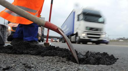 Flickschusterei: Ein Asphaltschaden auf der Autobahn A5 unweit des Frankfurter Kreuzes wird mit Kaltmischgut repariert.