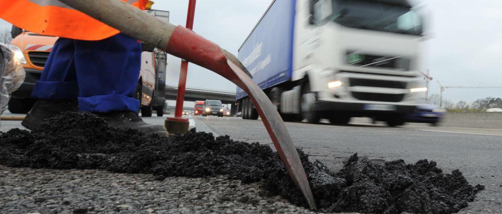 Flickschusterei: Ein Asphaltschaden auf der Autobahn A5 unweit des Frankfurter Kreuzes wird mit Kaltmischgut repariert.