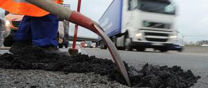 Flickschusterei: Ein Asphaltschaden auf der Autobahn A5 unweit des Frankfurter Kreuzes wird mit Kaltmischgut repariert.