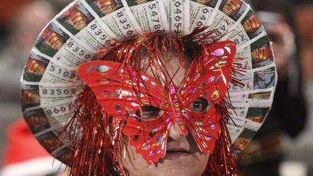 Eine Frau trägt einen Hut aus Losen für die Weihnachtslotterie - um ihrem Glück auf die Sprünge zu helfen.  
