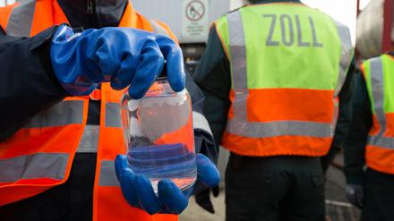 Eine Mitarbeiterin nimmt am Donnerstag im Klärwerk von Hetlingen (Schleswig-Holstein) bei Hamburg unter der Aufsicht von Zollbeamten eine Probe während der Vernichtung von knapp 25.000 Liter gefälschtem Tequila.