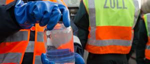 Eine Mitarbeiterin nimmt am Donnerstag im Klärwerk von Hetlingen (Schleswig-Holstein) bei Hamburg unter der Aufsicht von Zollbeamten eine Probe während der Vernichtung von knapp 25.000 Liter gefälschtem Tequila.