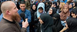 Der radikale Salafistenprediger Pierre Vogel (l) spricht bei einer Kundgebung in Offenbach am Main (Hessen).