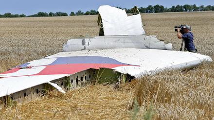 Ein Kameramann filmt Teile der Maschine im Juli 2014 im Osten der Ukraine.