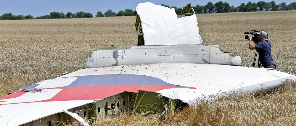 Ein Kameramann filmt Teile der Maschine im Juli 2014 im Osten der Ukraine.