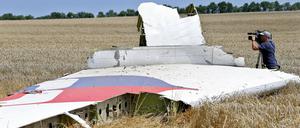 Ein Kameramann filmt Teile der Maschine im Juli 2014 im Osten der Ukraine.