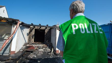 Ein Spurenermittler der Polizei steht vor dem ehemaligen Landgasthof, der in der Nacht in Brand geraten war.
