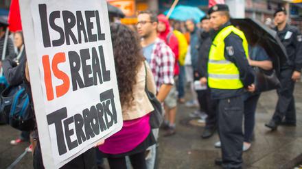 Aktivisten demonstrieren aus Anlass des Gazakriegs im Juli 2014 bei einer Kundgebung linker und kurdischer Gruppen am Kottbuser Tor in Berlin mit einem Schild "Israel is real Terrorist" (Israel ist der wirkliche Terrorist).