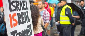 Aktivisten demonstrieren aus Anlass des Gazakriegs im Juli 2014 bei einer Kundgebung linker und kurdischer Gruppen am Kottbuser Tor in Berlin mit einem Schild "Israel is real Terrorist" (Israel ist der wirkliche Terrorist).  