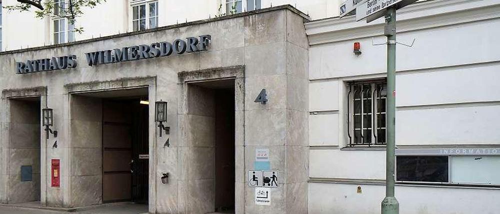 Relikt des Rathauses. Fünf Monate nach der Räumung am Fehrbelliner Platz soll der irreführende Schriftzug weichen. Die Schilder rechts weisen auf Partnergemeinden des Bezirks hin.