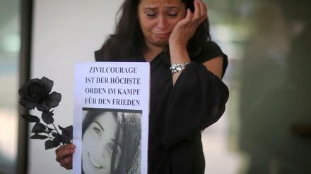Angehörige und Freunde von Tugce trauern am Dienstag vor dem Landgericht in Darmstadt (Hessen) nach der Urteilsverkündung und halten Bilder von ihr. Das Gericht verurteilte ihn wegen des gewaltsamen Todes der Studentin Tugce A. zu drei Jahren Haft.