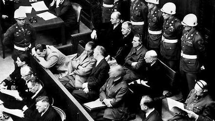 Die Angeklagten bei der Eröffnung des Nürnberger Kriegsverbrecher-Hauptprozesses am 20. November 1945. In der zweiten Reihe sitzen (v.l.) Hermann Göring, Rudolf Hess, Joachim von Ribbentrop, Wilhelm Keitel, Alfred Rosenberg und Hans Frank. In der hinteren Reihe sind (von links) die Angeklagten Karl Dönitz, Erich Räder, Baldur von Schirach, Fritz Sauckel und Alfred Jodl zu sehen. 