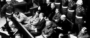 Die Angeklagten bei der Eröffnung des Nürnberger Kriegsverbrecher-Hauptprozesses am 20. November 1945. In der zweiten Reihe sitzen (v.l.) Hermann Göring, Rudolf Hess, Joachim von Ribbentrop, Wilhelm Keitel, Alfred Rosenberg und Hans Frank. In der hinteren Reihe sind (von links) die Angeklagten Karl Dönitz, Erich Räder, Baldur von Schirach, Fritz Sauckel und Alfred Jodl zu sehen. 