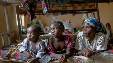 Rose Zeeharrah (r), liegt am 16.03.2015 in einem Flüchtlingscamp im Nordosten Nigerias neben ihren Kindern auf einem Bett. Bei einem Angriff der Boko-Haram-Rebellen verlor sie ihren Ehemann.