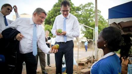 Hermann Gröhe (l.) und Gerd Müller im Gespräch mit einer Papaya-Verkäuferin vor der Uni-Klinik in der ghanaischen Hauptstadt Accra. Im Hintergrund: Der Ebola-Beauftragte der Bundesregierung, Walter Lindner.
