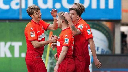 Held des Tages: Kaiserslauterns Jean Zimmer (2.vl) wird nach seinem Tor zum 1:0 von Ruben Jenssen (l) und Simon Zoller geherzt.