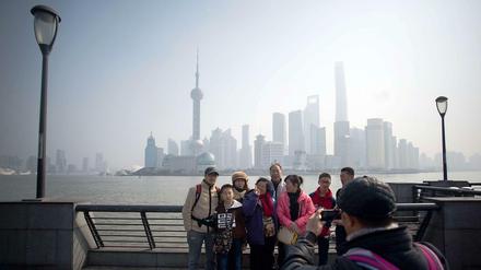 Eine Gruppe Touristen vor der Skyline von Pudong in Shanghai.