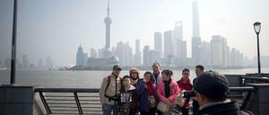 Eine Gruppe Touristen vor der Skyline von Pudong in Shanghai.