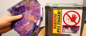 Die Deutsche Bahn stellt am Dienstag eine neue Sicherheitstechnik für Fahrausweisautomaten vor, die bei Gewalteinwirkung die Geldscheine und die Täter mit Farbe und DNA besprühen. Die Banknoten (l) in den Geldkassetten (r) werden damit unbrauchbar gemacht. 