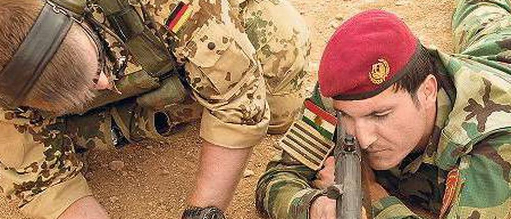 Im Sand von Erbil. Ein Soldat der Bundeswehr unterweist einen Peschmerga-Kämpfer auf einer Schießanlage in der Bedienung eines G3-Sturmgewehres.