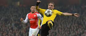 Marcel Schmelzer (r.) müht sich mit dem Ball und gegen Alex Oxlade-Chamberlain (l.).