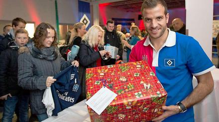 Was da wohl drin ist? Rafael van der Vaart vom Hamburger SV nimmt Geschenke für hilfsbedürftigen Menschen entgegen.