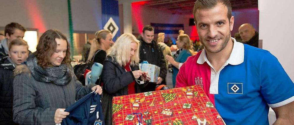 Was da wohl drin ist? Rafael van der Vaart vom Hamburger SV nimmt Geschenke für hilfsbedürftigen Menschen entgegen.