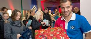 Was da wohl drin ist? Rafael van der Vaart vom Hamburger SV nimmt Geschenke für hilfsbedürftigen Menschen entgegen.