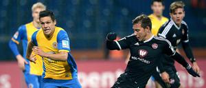 Braunschweigs Mirko Boland (l) zieht an Nürnbergs Robert Koch vorbei.