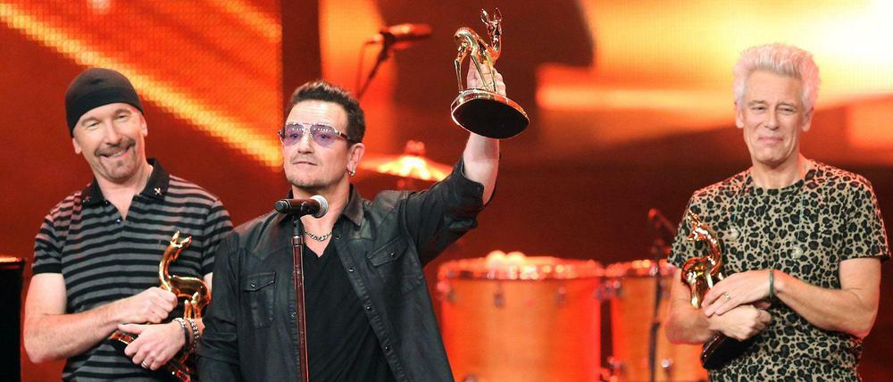 Zurück in Berlin: Bono (Mitte) und seine Weggefährten von U2, The Edge (links) und Adam Clayton (rechts) mit ihren Bambis.