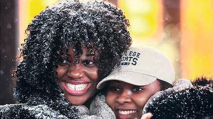 Frauen auf dem Times Square freuen sich über die Schneeflocken.