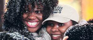 Frauen auf dem Times Square freuen sich über die Schneeflocken.