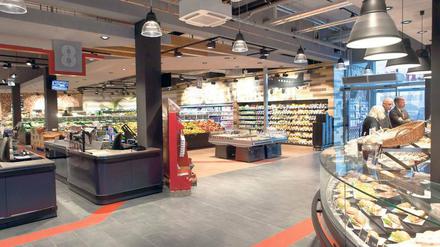 Ein neu gestalteter Supermarkt mit hellen Lampen und viel Platz auf den Gängen. 