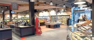 Ein neu gestalteter Supermarkt mit hellen Lampen und viel Platz auf den Gängen. 
