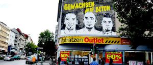 Drei Heldenköpfe an grauer Wand. Die Brüder Jerome, George und Kevin-Prince Boateng (von links) sind dauerhaft in den Wedding zurückgekehrt.