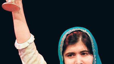 Malala hebt eine Preisstatuette in die Höhe