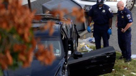 Polizisten vor dem Auto, dessen Fahrerin nach einer wilden Verfolgungsjagd erschossen wurde.