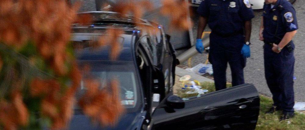 Polizisten vor dem Auto, dessen Fahrerin nach einer wilden Verfolgungsjagd erschossen wurde.