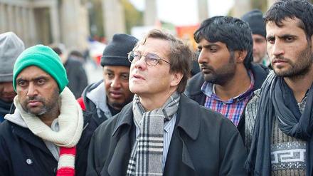 Bischof Dröge spricht vor dem Brandenburger Tor mit Flüchtlingen.