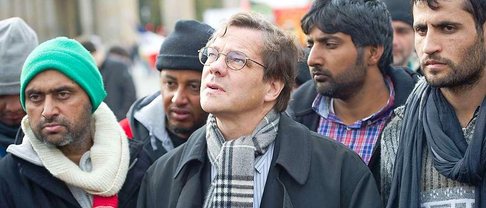 Bischof Dröge spricht vor dem Brandenburger Tor mit Flüchtlingen.