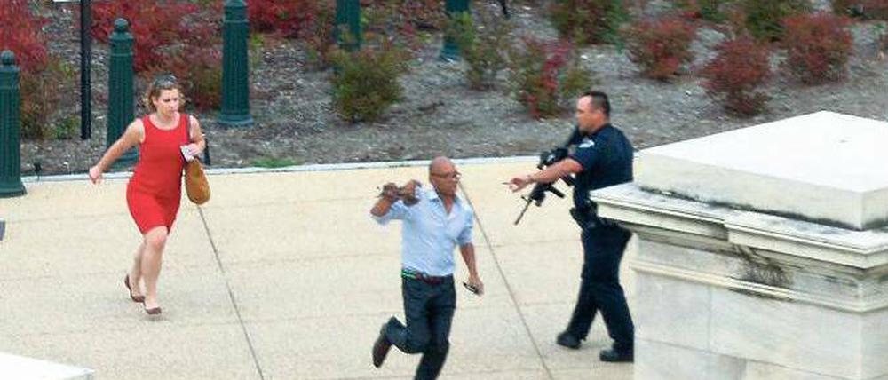 Die Angst läuft mit. Die Menschen in der Umgebung des Kapitols versuchen sich nach dem Vorfall in Sicherheit zu bringen. Der Sitz von Senat und Repräsentantenhaus wurde für mehr als eine halbe Stunde abgeriegelt. Foto: Mandel Ngan/ AFP