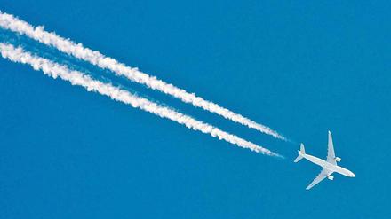 Ein Flugzeug hinterlässt am Himmel eine weiße Spur