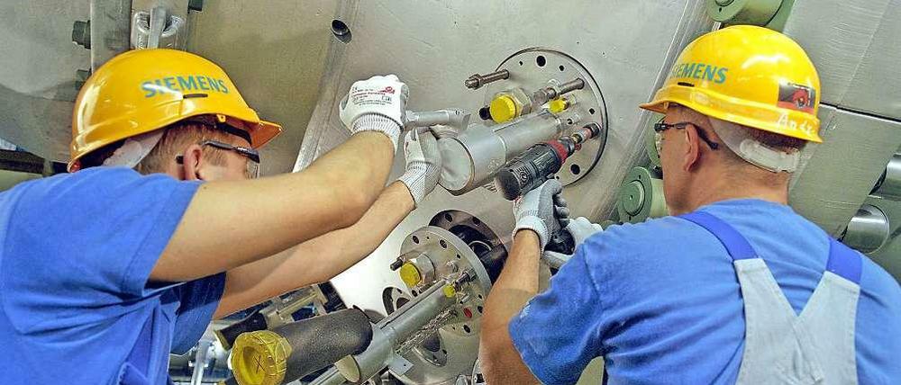 Gebaut in Moabit. Zwei Siemens-Mitarbeiter montieren Gasbrenner im Werk in der Huttenstraße. Künftig sollen die Gasturbinen noch effizienter werden. Die Arbeit daran findet ab Oktober 2014 in Ludwigsfelde statt.