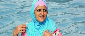 Im Burkini kühlt sich die Berlinerin Abir in einem Freibad in Berlin.