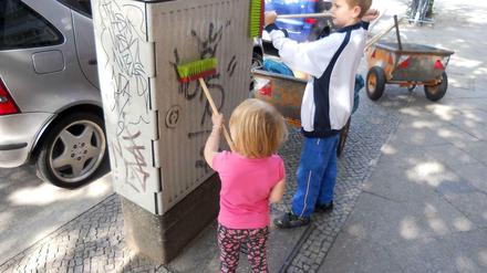 Mit ihren kleinen Besen haben die Kinder der 27 Helfer am Grazer Platz in Friedenau großen Spaß.