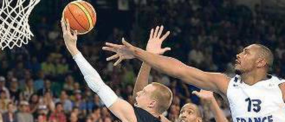 Mit links gepunktet. Robin Benzing erzielt zwei seiner insgesamt 19 Punkte, die Franzosen Alexis Ajinca (M.) und Boris Diaw (r.) kommen zu spät.