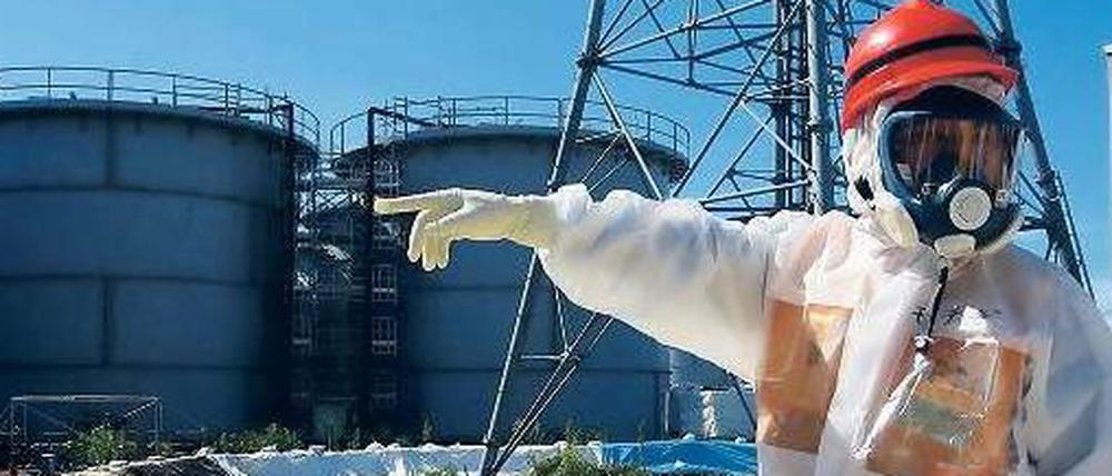 Besuch von oben. Der japanische Wirtschaftsminister Toshimitsu Motegi inspizierte am Montag die Anlage. Im Hintergrund Tanks für das strahlende Abwasser. 